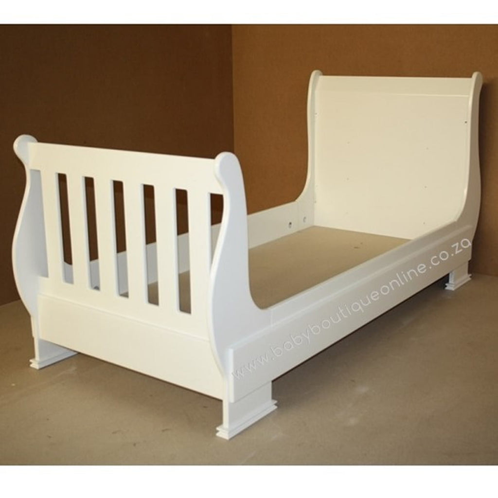 White  toddler bed wooden crib against a brown background