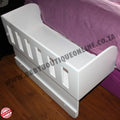 White baby co sleeper crib bumper on a bed with visible branding.