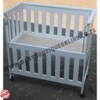 White co sleeper crib on a tiled floor with 'BabyBoutiqueOnline' branding.