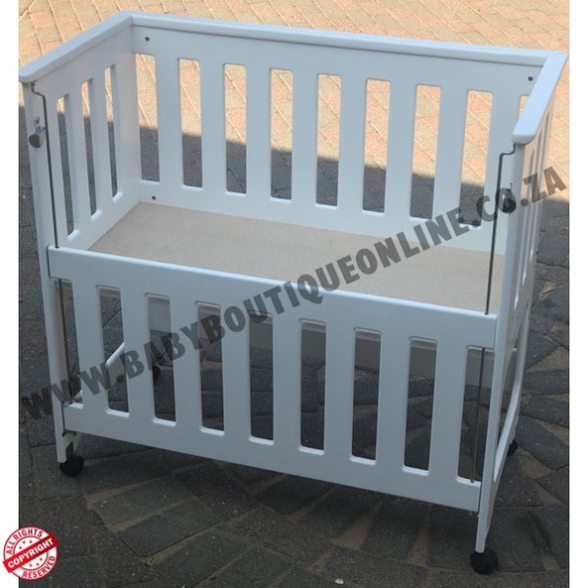White co sleeper crib on a tiled floor with 'BabyBoutiqueOnline' branding.