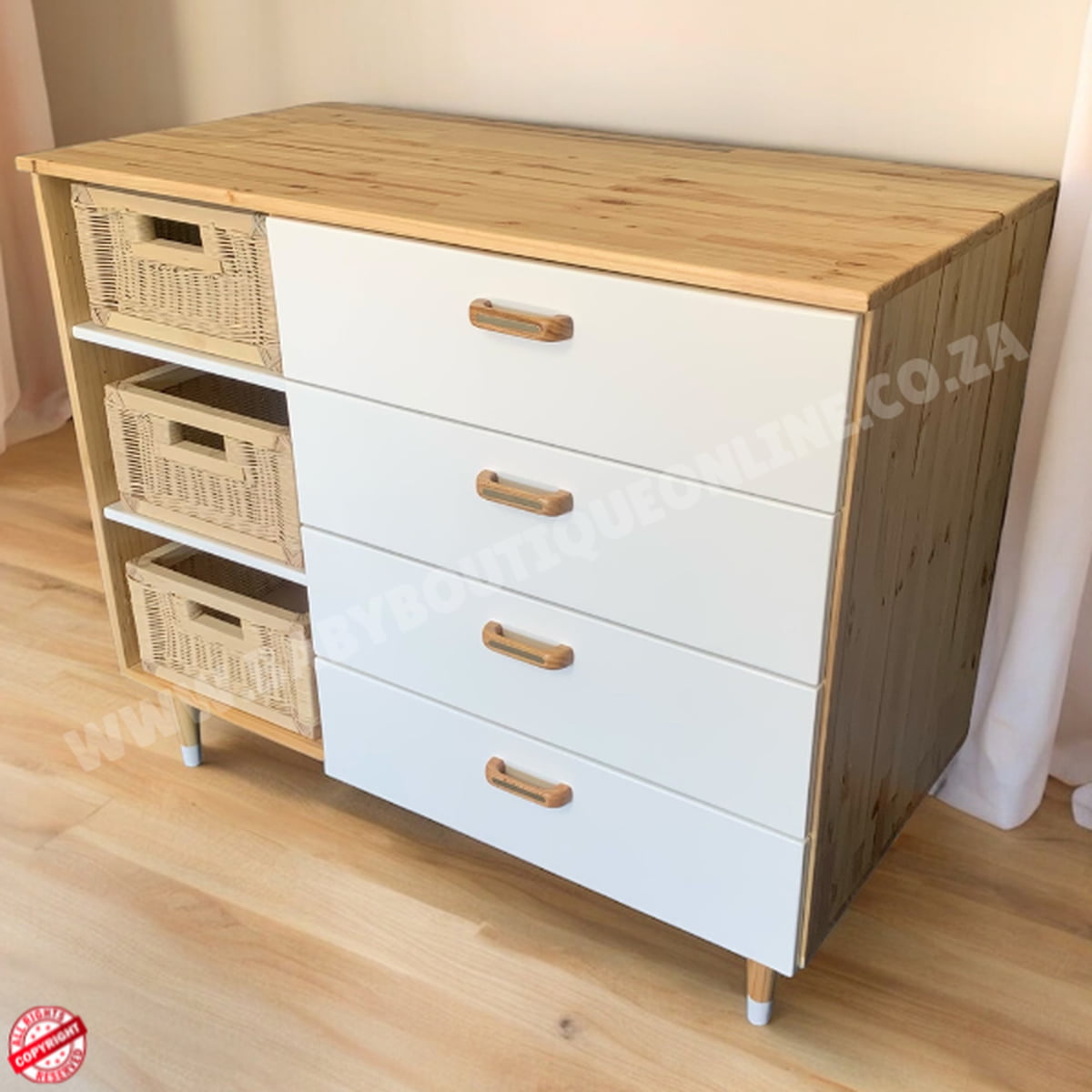 Wooden dresser with white drawers and wicker baskets on a wooden floor.