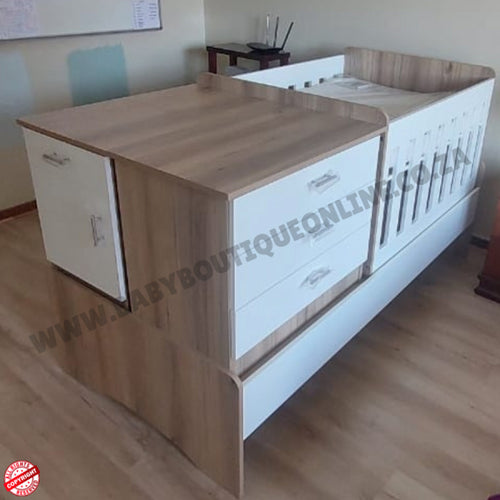 Wooden and whiteBabyBedroominaBox-5-in-1Cot rib with drawers in a room setting.
