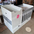 BabyBedroominaBox4-in-1White baby crib with gray accents and a pink flower design in a room setting.